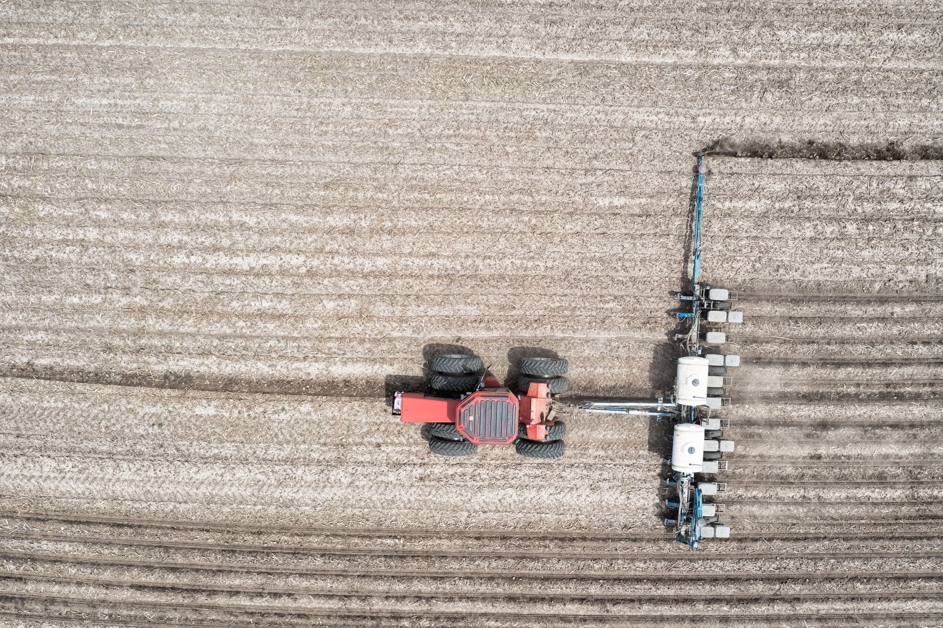 Aerial view of a red tractor working in a Saskatchewan field