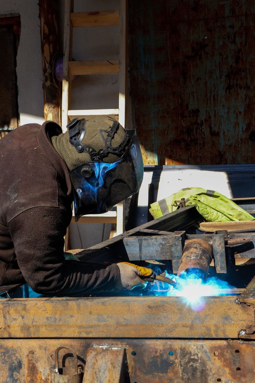 Welder working with sparks in an industrial workshop