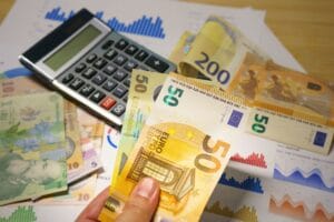 Financial documents, calculator and currency representing business expenses