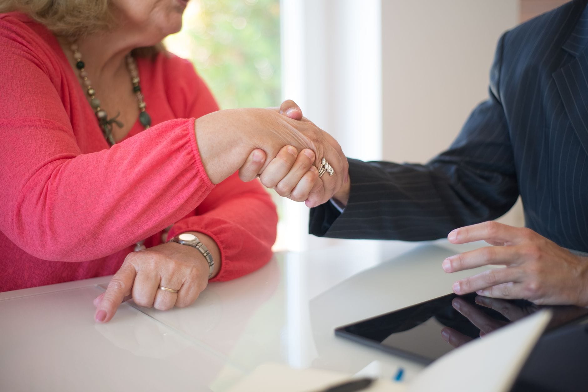 Professional handshake over a desk during a real estate meeting