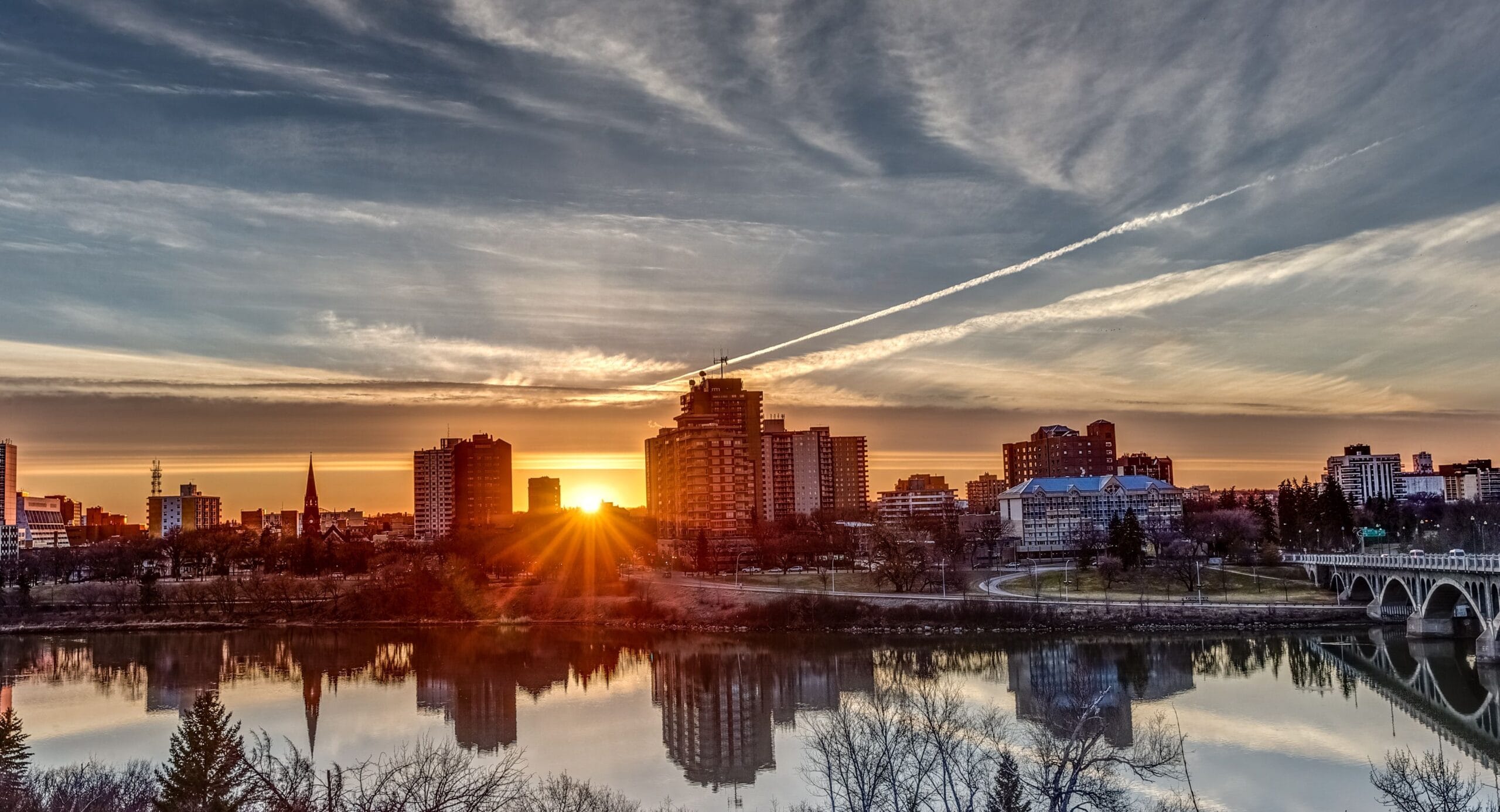 Saskatoon skyline at sunset with river reflection